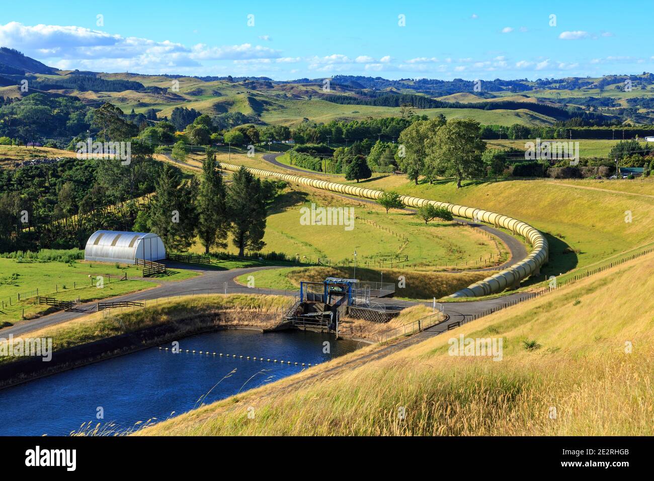 A water pipeline leading from a reservoir and curving off across the countryside. Part of a hydroelectric power scheme at Ruahihi, New Zealand Stock Photo