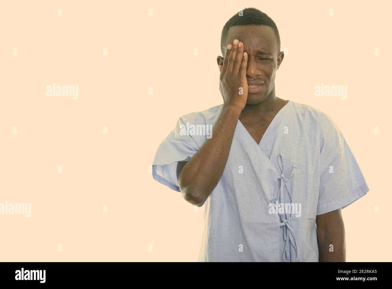 Studio shot of young black African man patient looking sad while ...