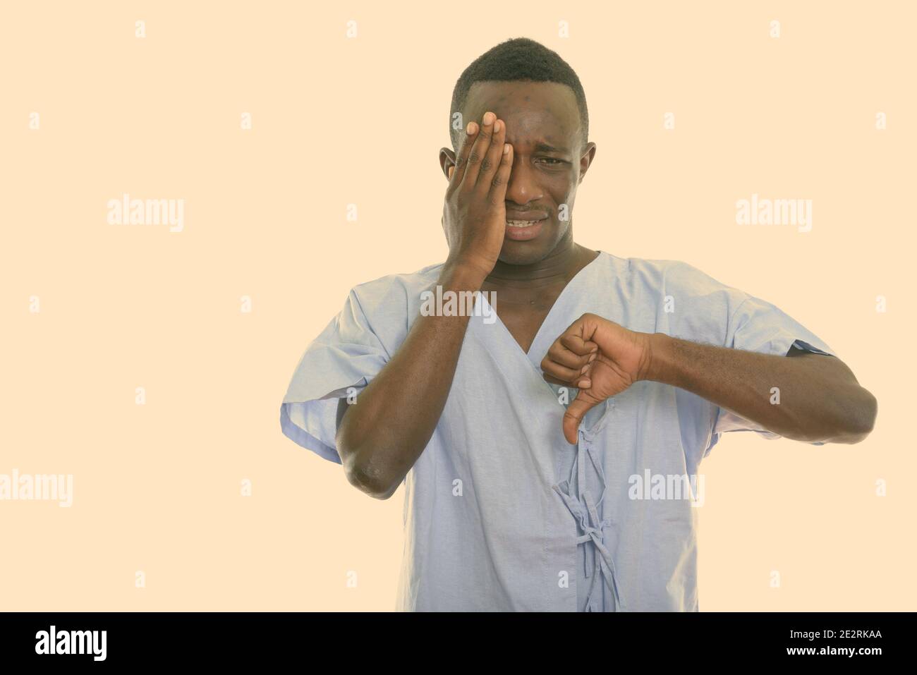Studio shot of young black African man patient looking sad while ...