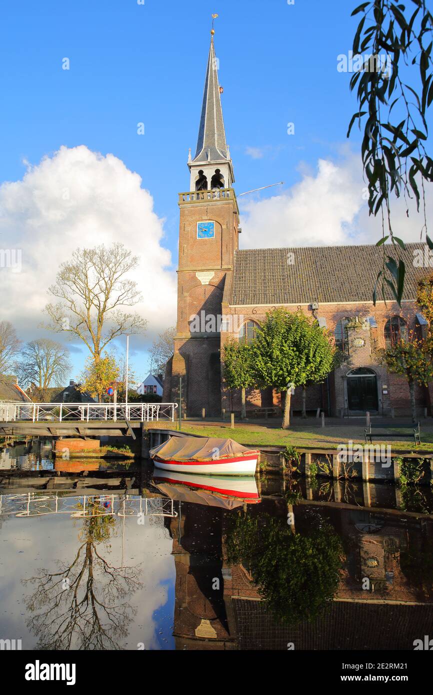 Broek in Waterland, a small town with traditional old and painted wooden houses, North Holland, Netherlands, with reflections of the church Stock Photo
