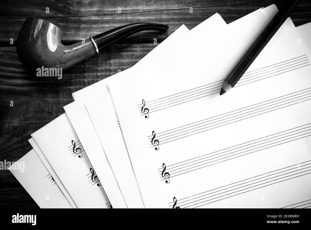 Blank music score paper and a smoking pipe in black and white. Stock Photo