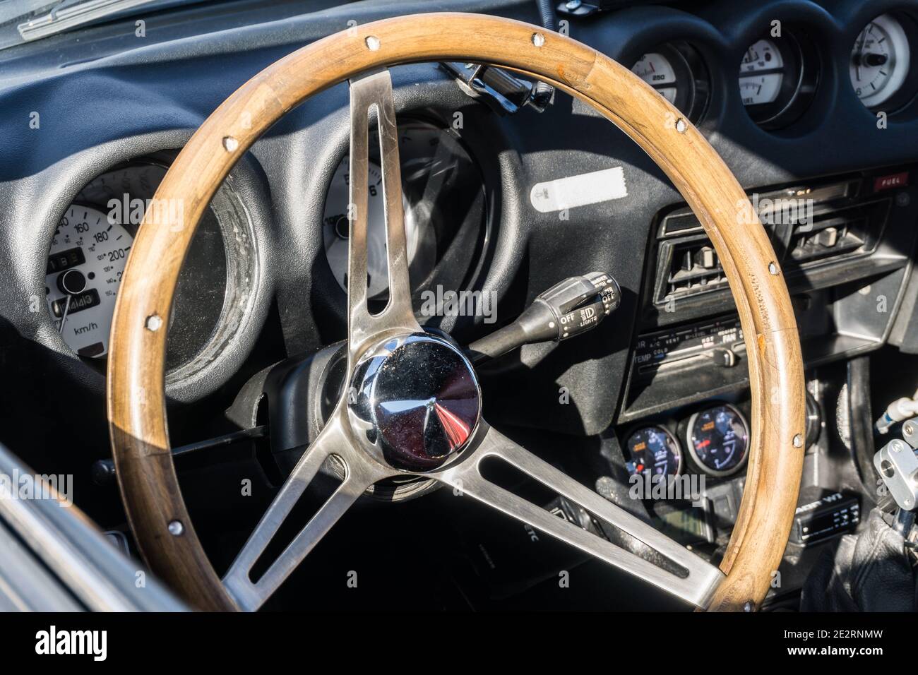 Close up detail of the steering wheel and dashboard of a matte black customised Datsun Fairlady 280Z GT coupe 1970s sports car Stock Photo