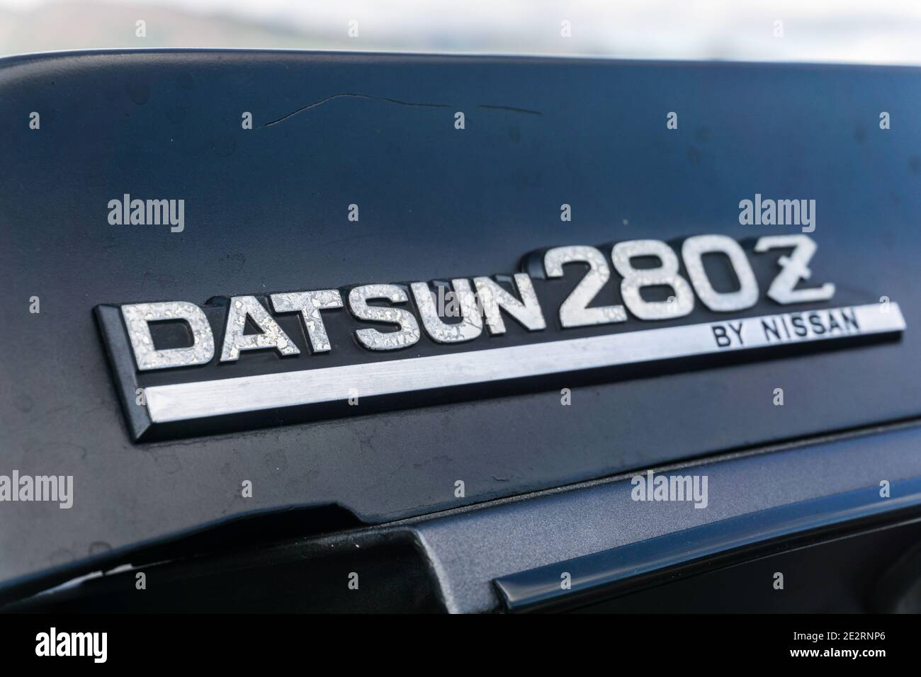 Close up detail of the brand logo badge on a matte black customised Datsun Fairlady 280Z GT coupe 1970s sports car Stock Photo