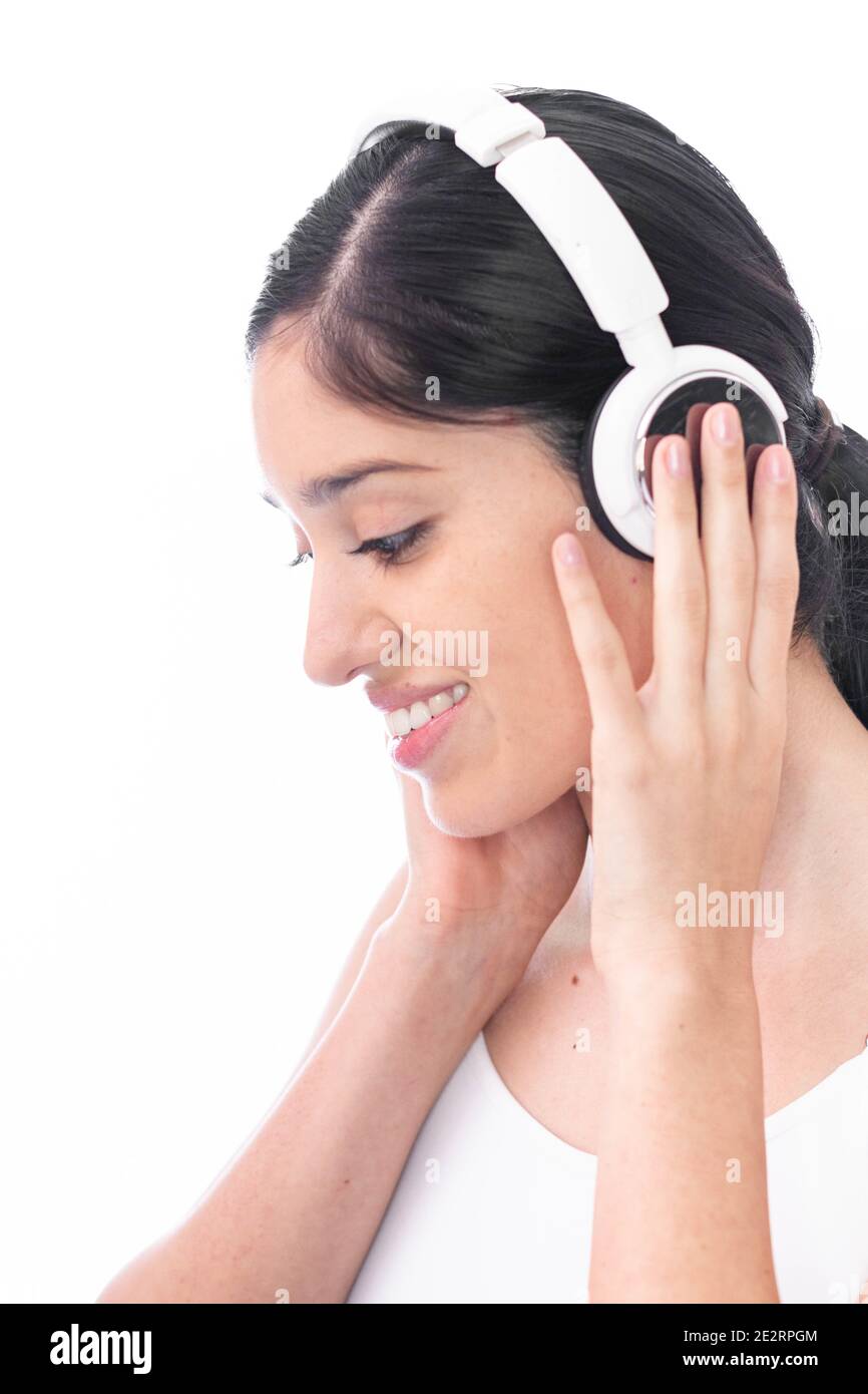 Vertical closeup of a Hispanic female enjoying music on her headphones ...