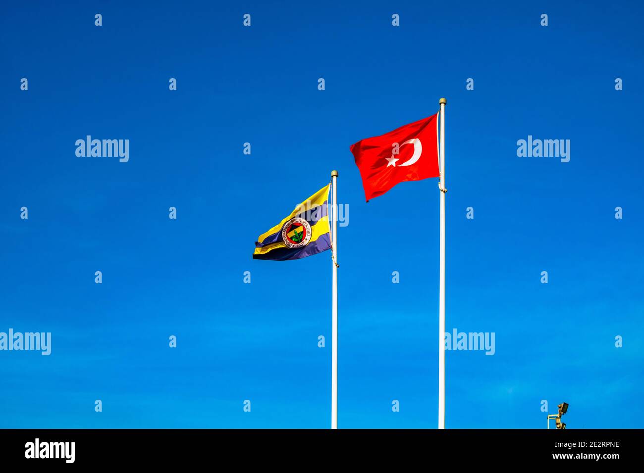 Istanbul Turkey - 1.4.2021: Flags of Fenerbahce SK and Turkey against the blue sky. Stock Photo