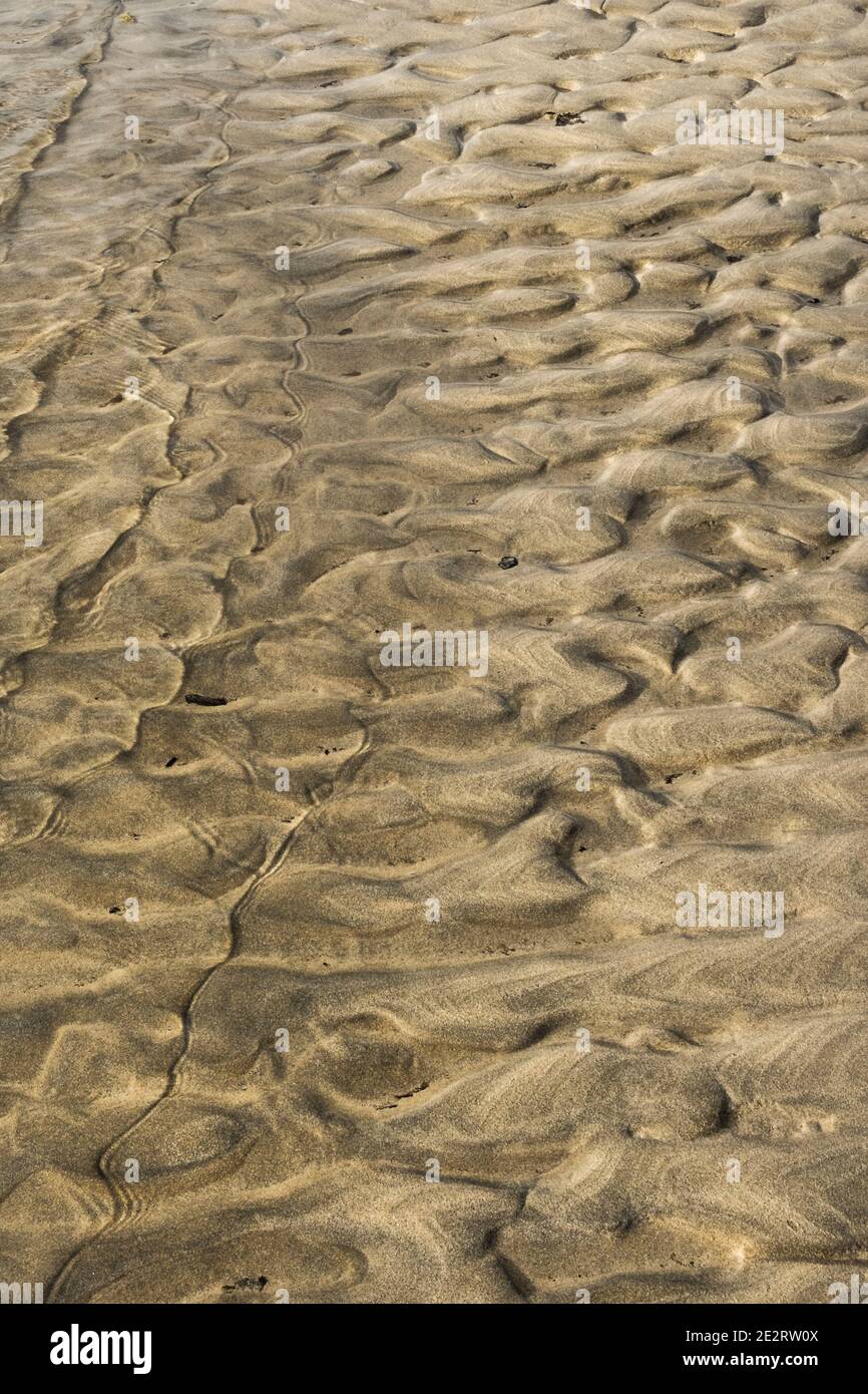 The waters of the River Gannel lapping over sand ripples. Stock Photo