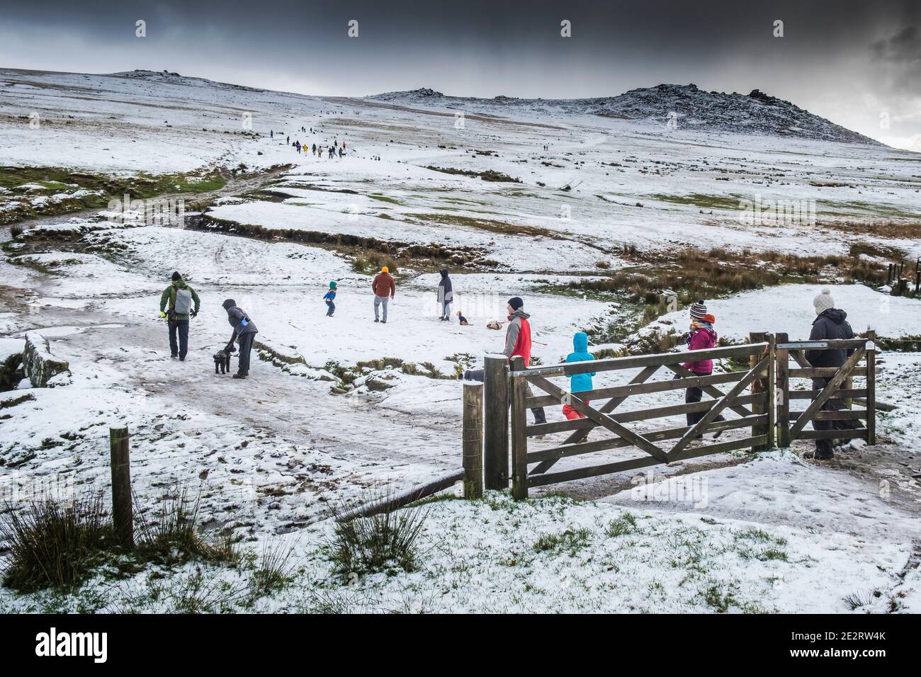 People walking in the snow on the wild rugged Rough Tor on Bodmin Moor in Cornwall. Stock Photo