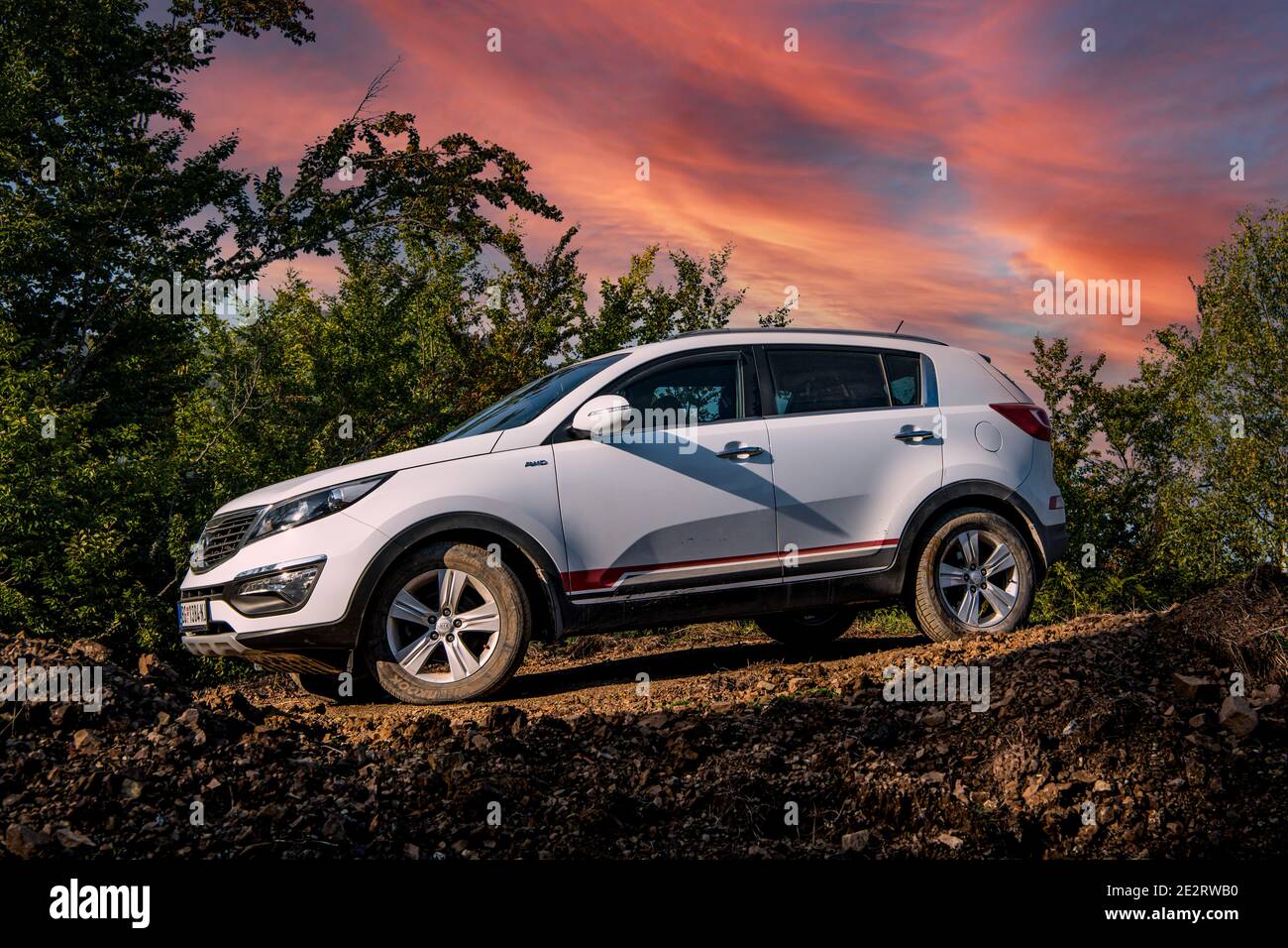 Kia Sportage 2.0 CRDI awd or 4x4, white color, parked on a gravel road, with beautiful orange sunset in the background.  Best car for off road. Tara Stock Photo
