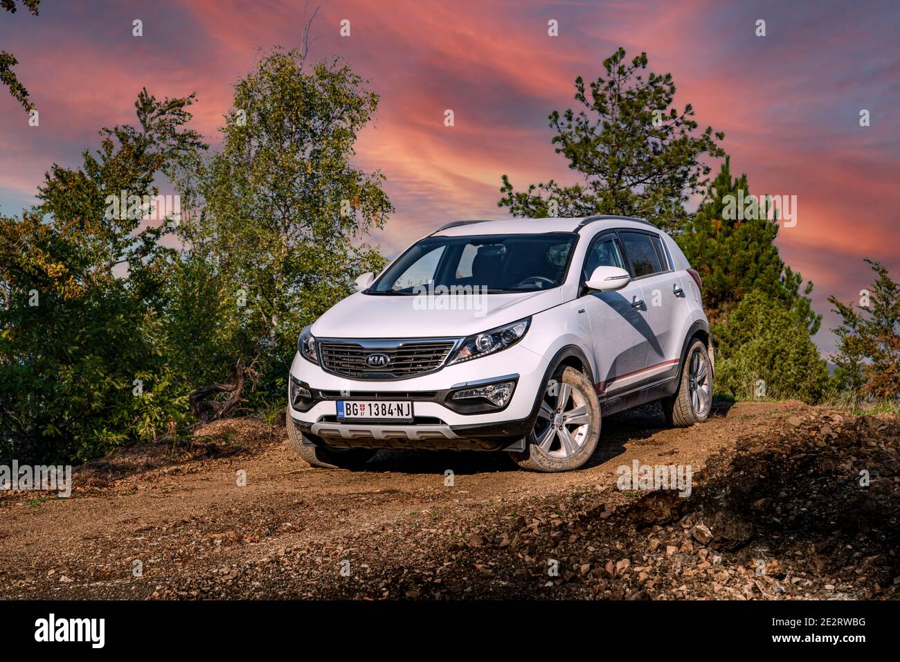 Kia Sportage 2.0 CRDI awd or 4x4, white color, parked on a gravel road, with beautiful orange sunset in the background.  Best car for off road. Tara Stock Photo