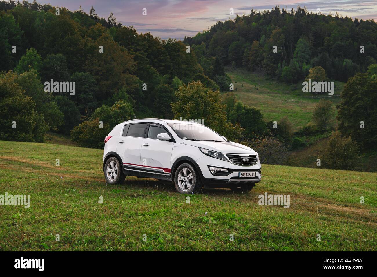 Kia Sportage 2.0 CRDI awd or 4x4, white color, parked on a gravel road, with beautiful orange sunset in the background.  Best car for off road.Zaovine Stock Photo