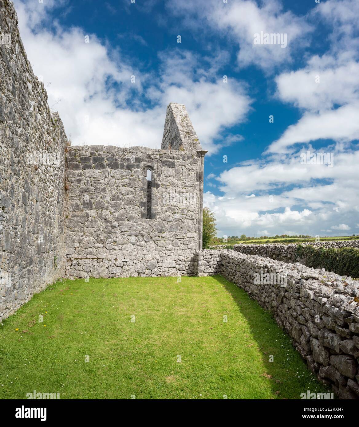 Ruined buildings and stone walls constucted from Carboniferous limestone at the 7th century Kilmacduagh monastery near Gort, County Galway, Ireland Stock Photo