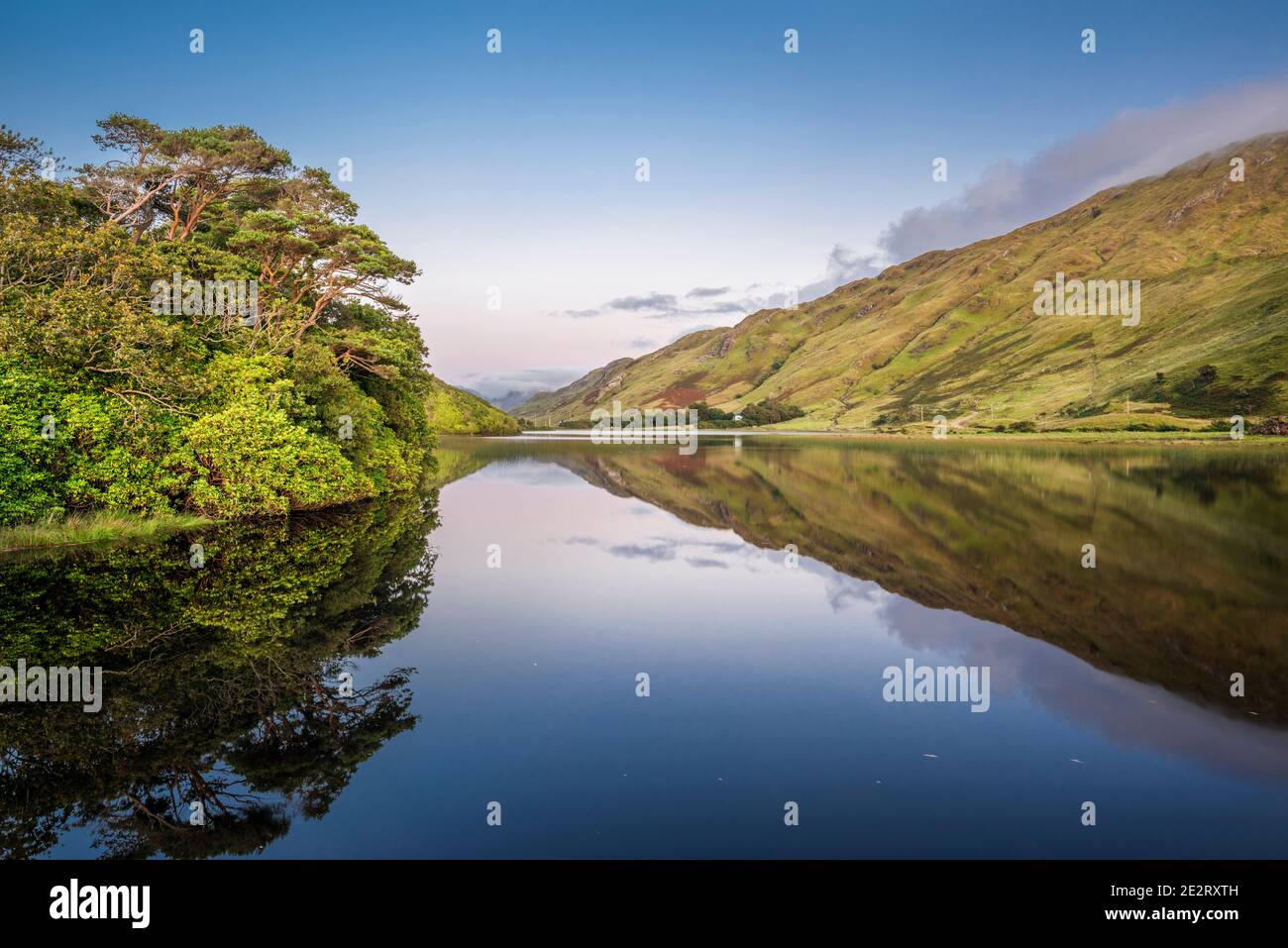 Kylemore Lough, Connemara, Co Galway, is almost perfectly still just after sunset with a perfect reflection Stock Photo