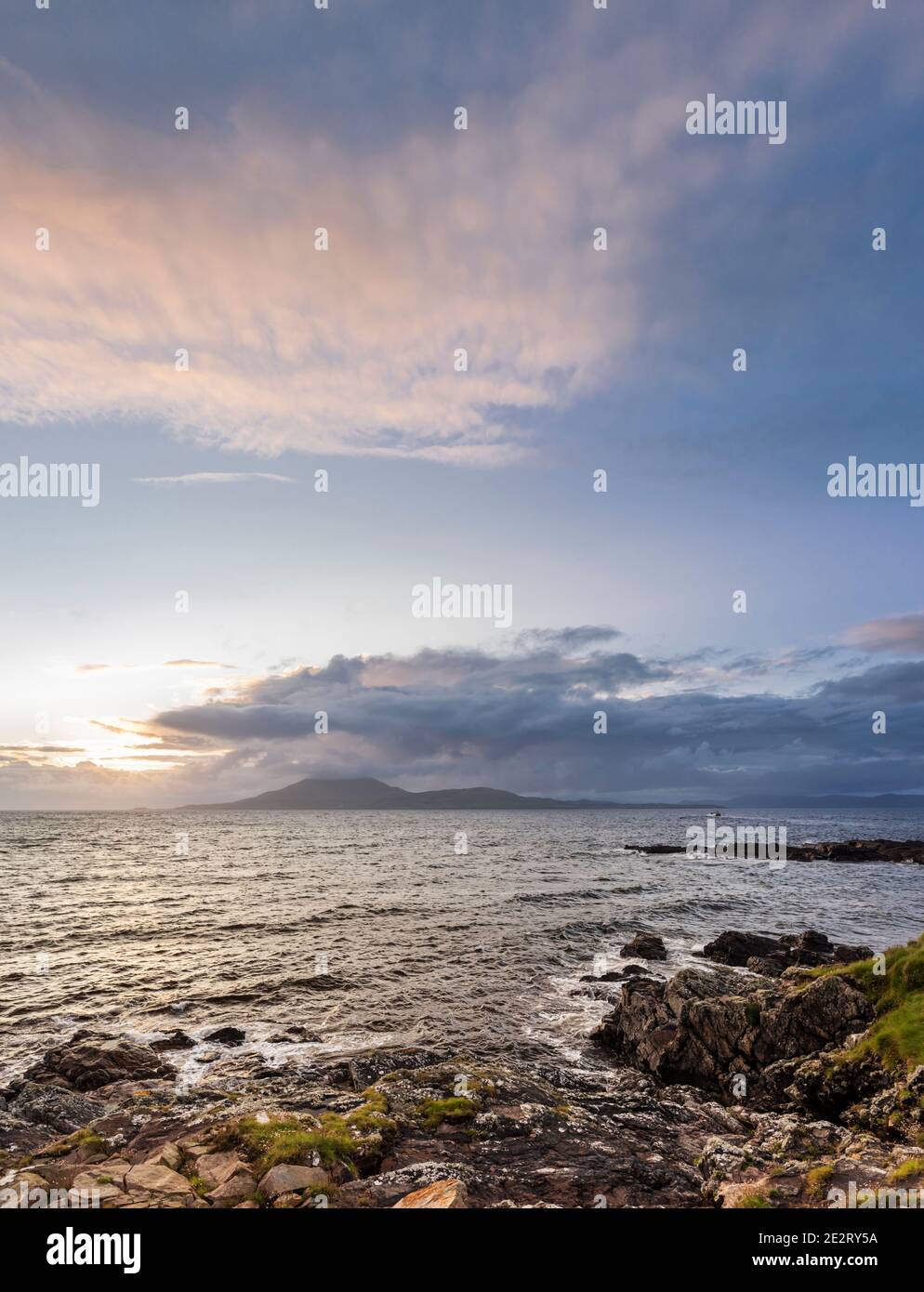 View across a turbulent sea at sunset towards Clare Island from Roonagh Pier, west of Louisburg, County Mayo, Ireland Stock Photo