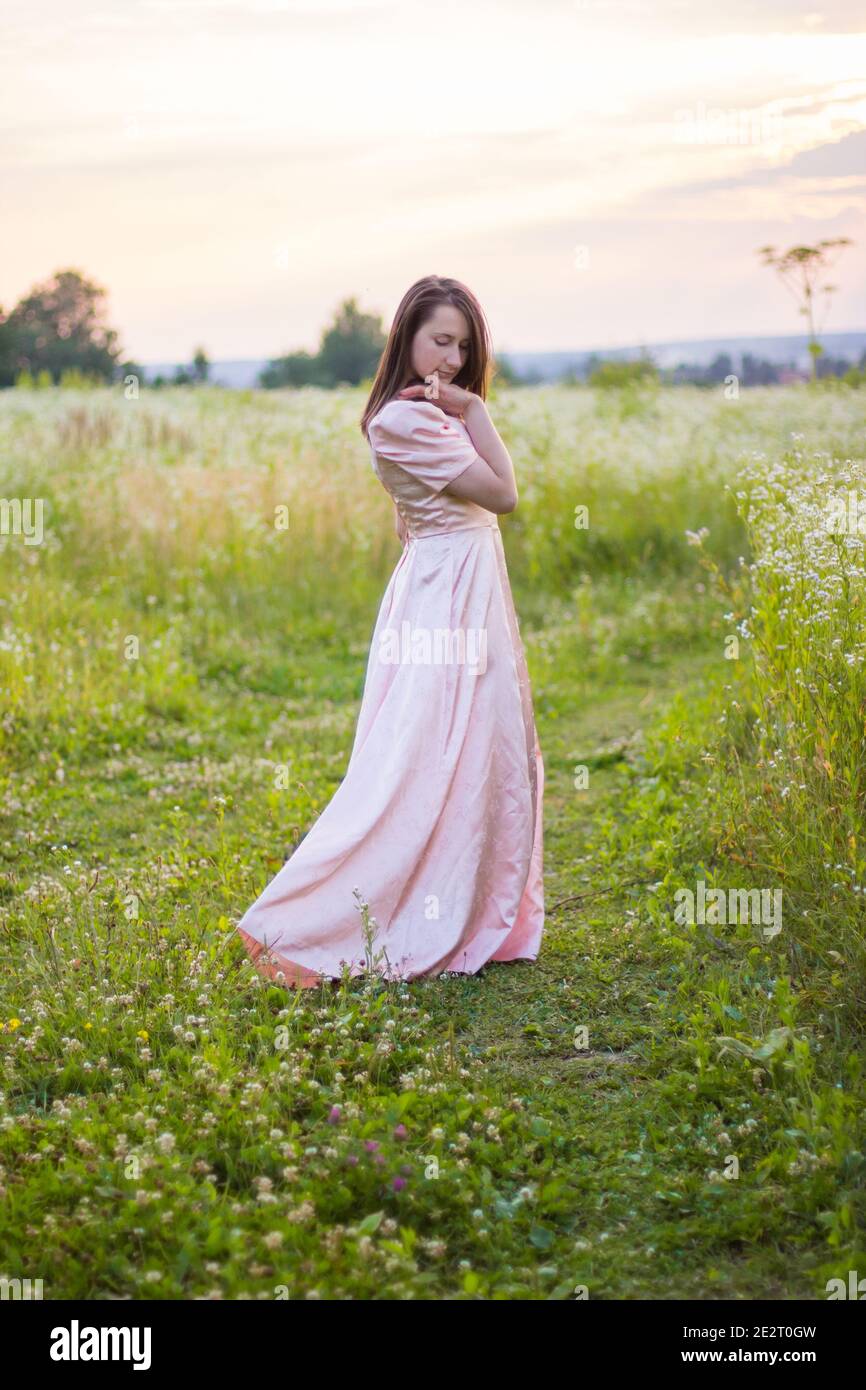 girl standing in the field in a pink dress Stock Photo - Alamy