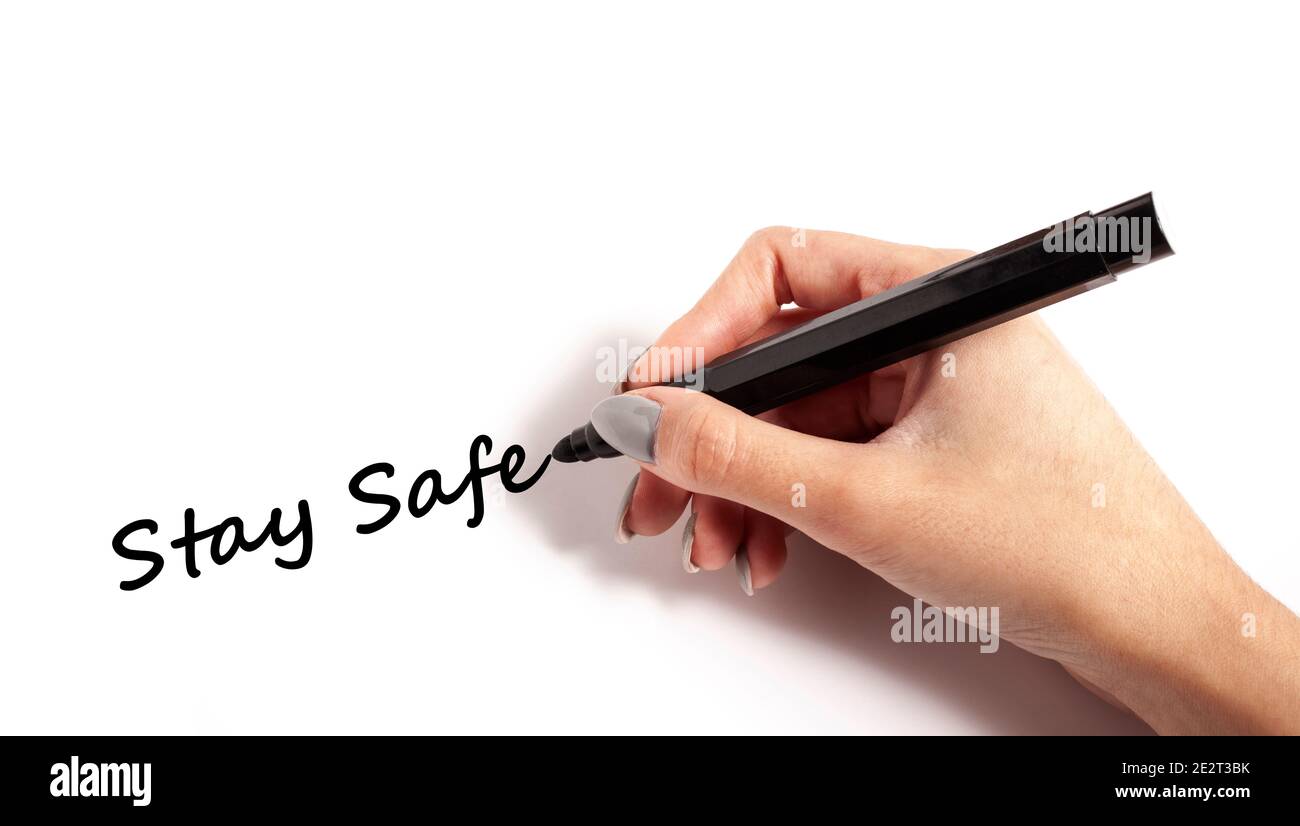 Hand holding pen writing stay safe on white paper Stock Photo Alamy