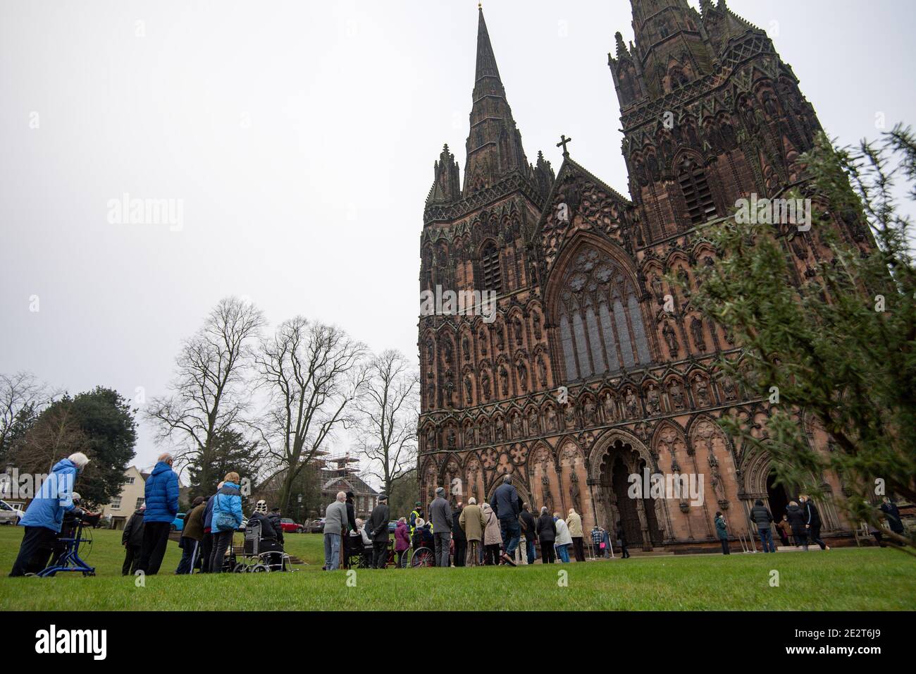 Members of the public queue outside Lichfield Cathedral, Staffordshire, to receive an injection of the Oxford/AstraZeneca coronavirus vaccine. Stock Photo