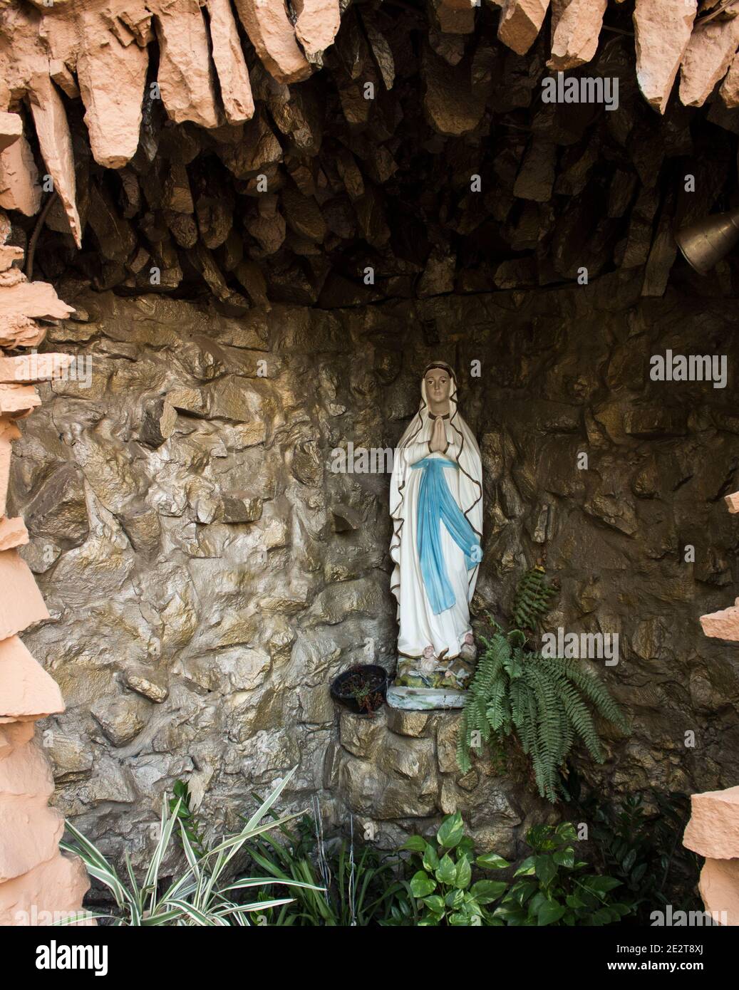 Artificial grotto with a Holy Mary statue inside for prayers Stock Photo