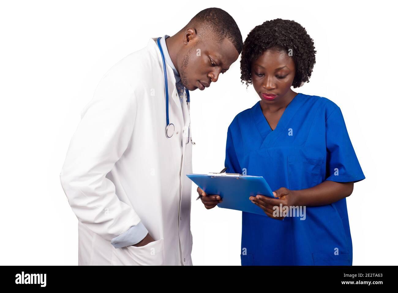 doctor and trainee standing checking medical file of a patient in paper-press. Stock Photo