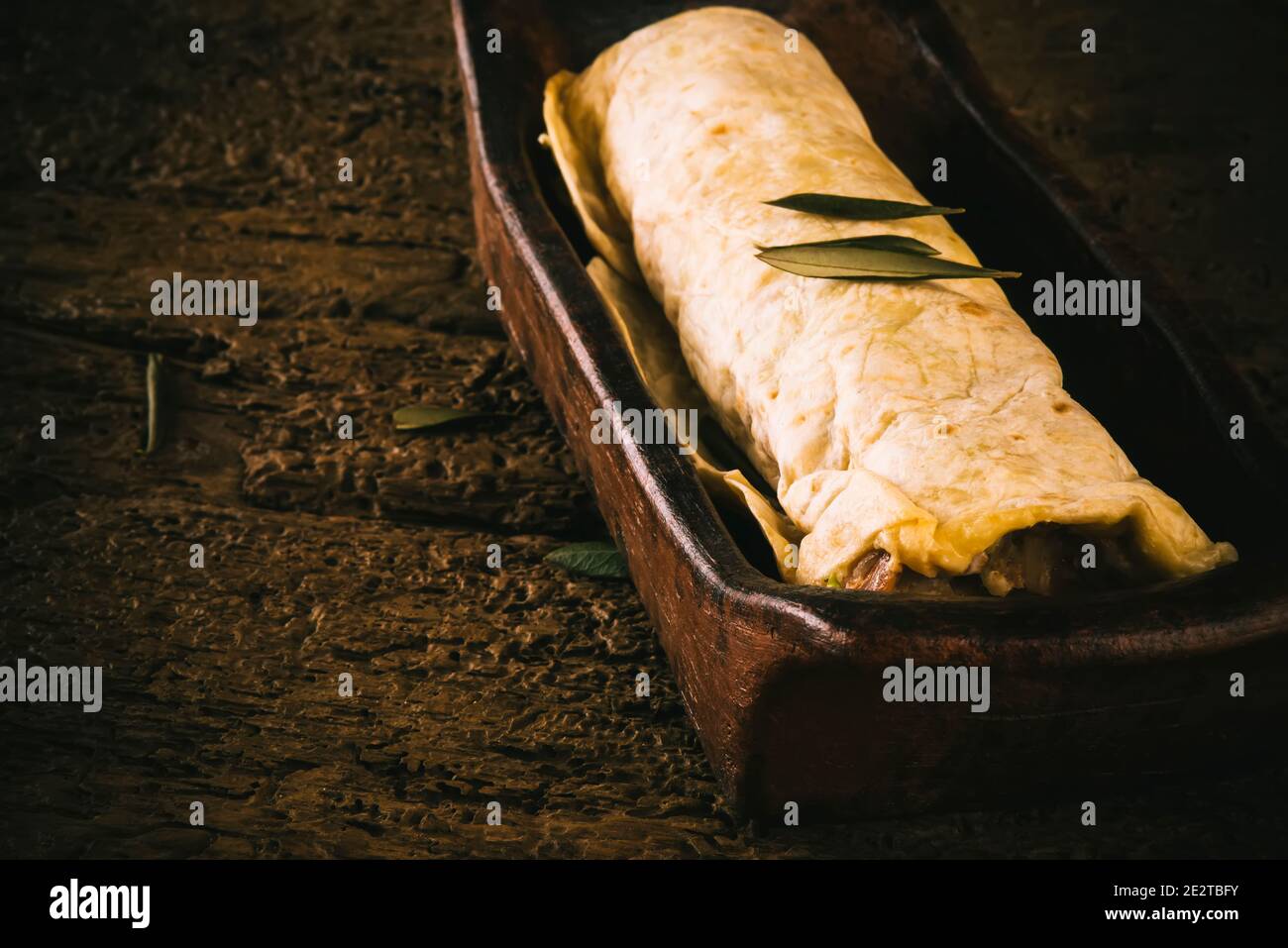 Homemade Durum Kebab in clay tray on an old wooden table Stock Photo