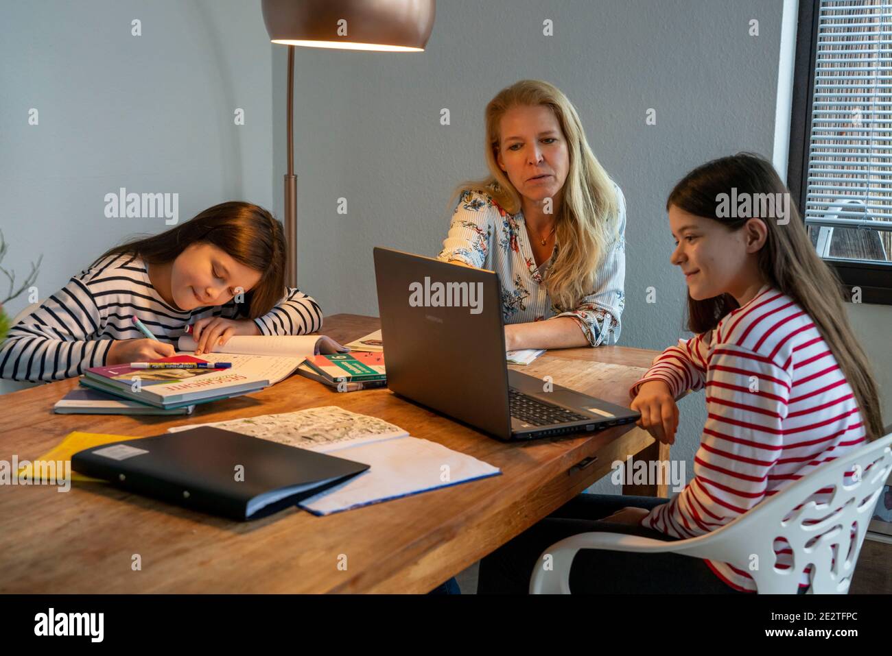 Homeschooling, during the lockdown in January 2021, mother helps her ...