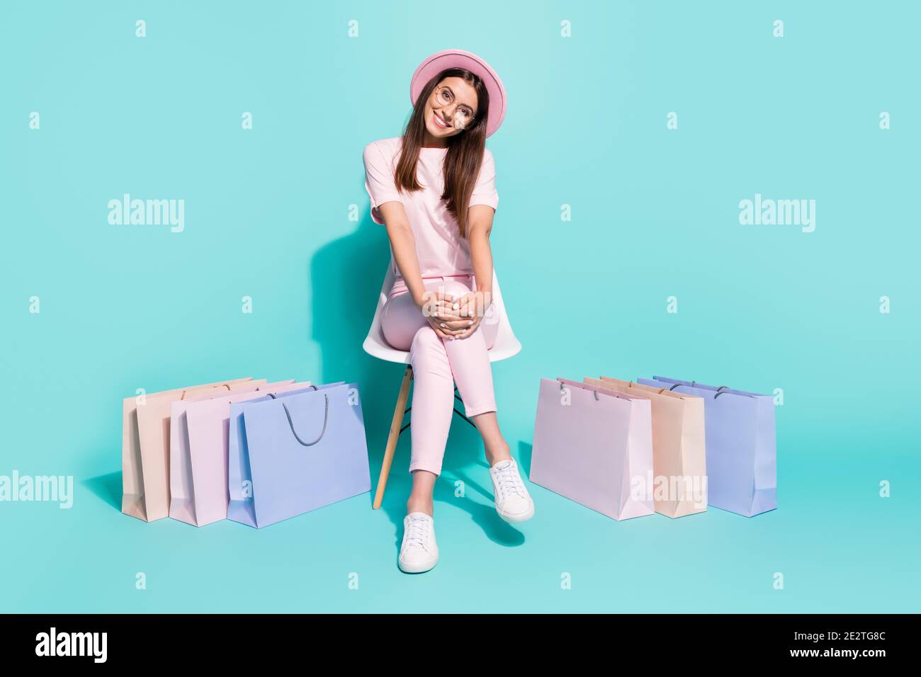 Portrait of her she nice-looking attractive pretty cute cheerful cheery girl fashionista sitting in chair among bags new clothes isolated on bright Stock Photo