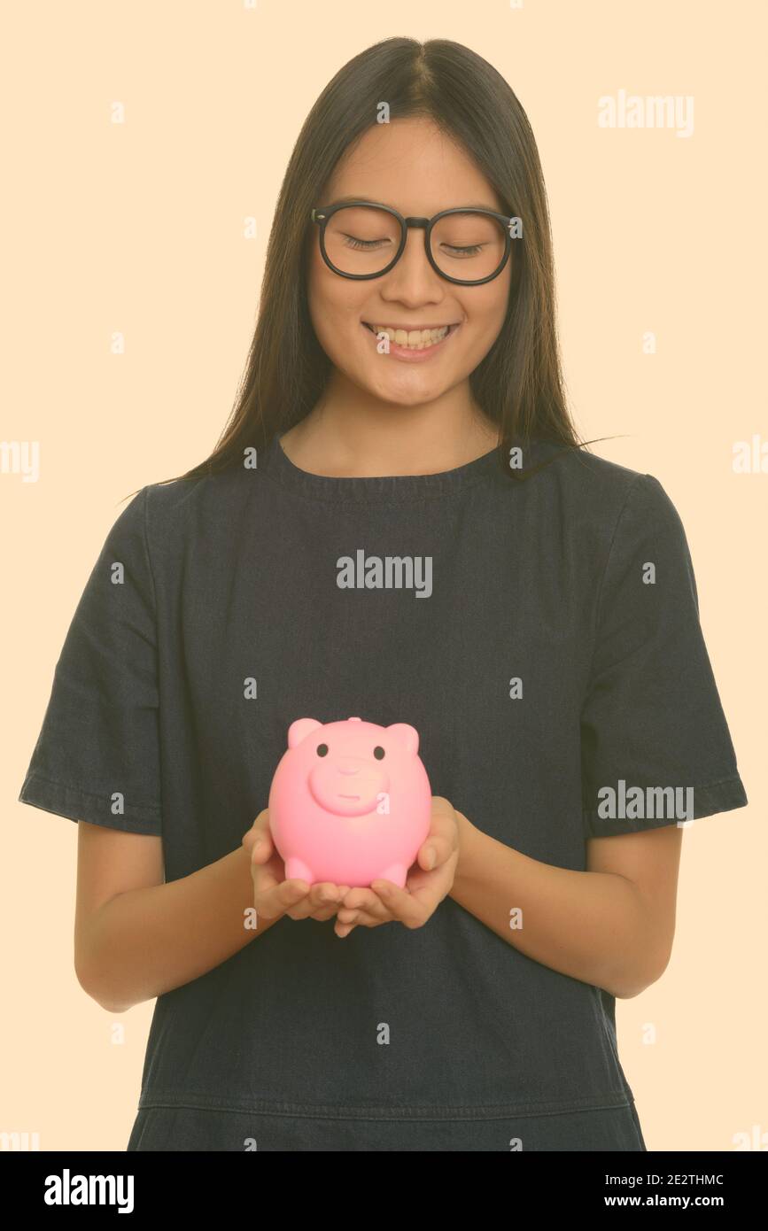 Young happy Asian teenage girl smiling and holding piggy bank Stock ...