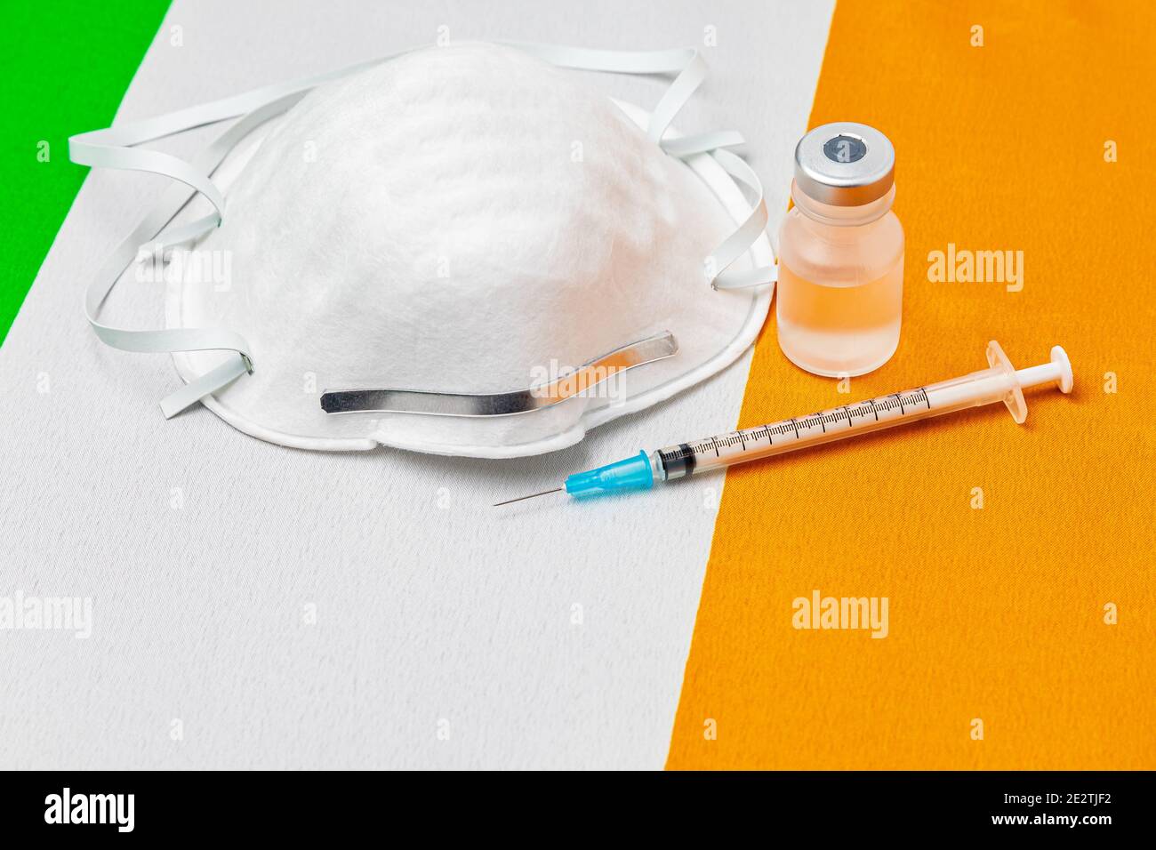 Ireland flag, n95 face mask, needle syringe and vial. Concept of Covid-19 coronavirus vaccine distribution, supply shortage and healthcare crisis Stock Photo