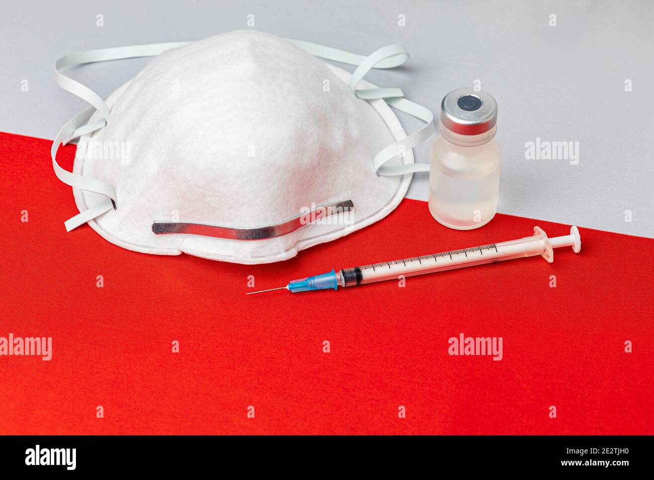 Poland flag, n95 face mask, needle syringe and vial. Concept of Covid-19 coronavirus vaccine distribution, supply shortage and healthcare crisis Stock Photo