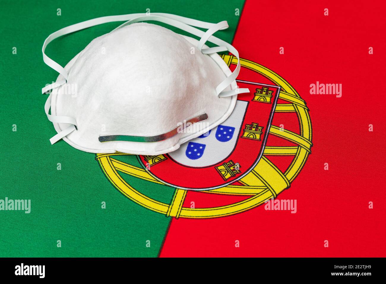 Portugal flag and N95 face mask. Concept of Covid-19 coronavirus lockdown, travel ban and healthcare crisis Stock Photo