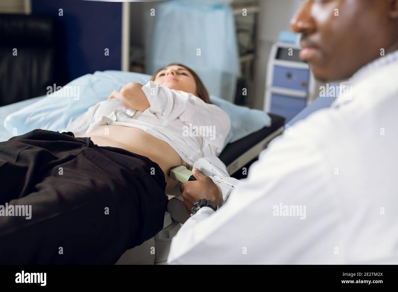 Extracorporeal shockwave therapy in urology. Cropped shot of lying woman patient, having ultrasound diagnostics to determine kidney stones position Stock Photo