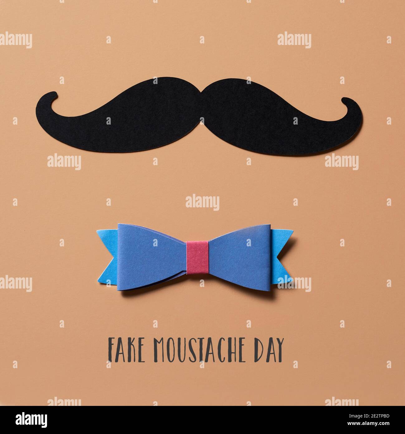 closeup of a moustache, made with a cutout of a black cardboard, a bow