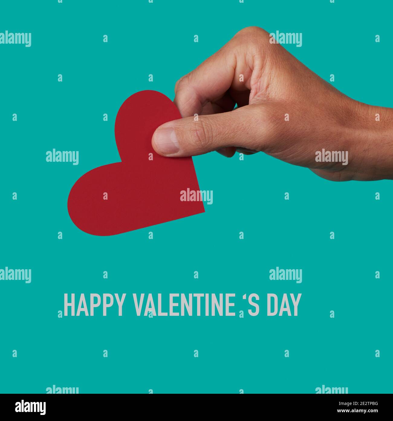 closeup of a man with a red heart in his hand and the text happy ...
