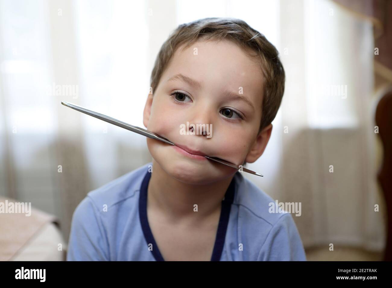 Child holding a knife in his mouth Stock Photo Alamy