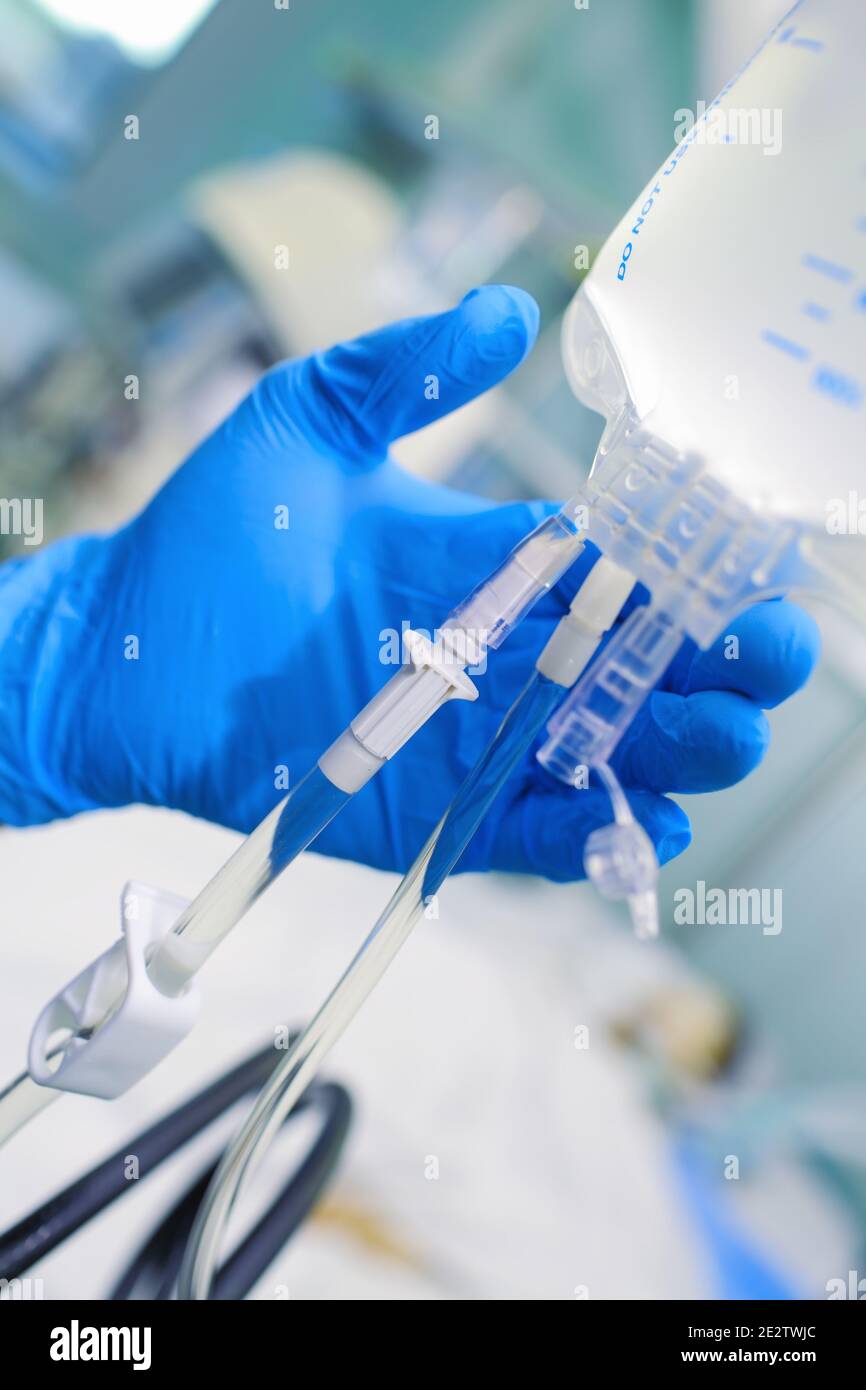 Doctor checks up the intravenous drip system. Stock Photo
