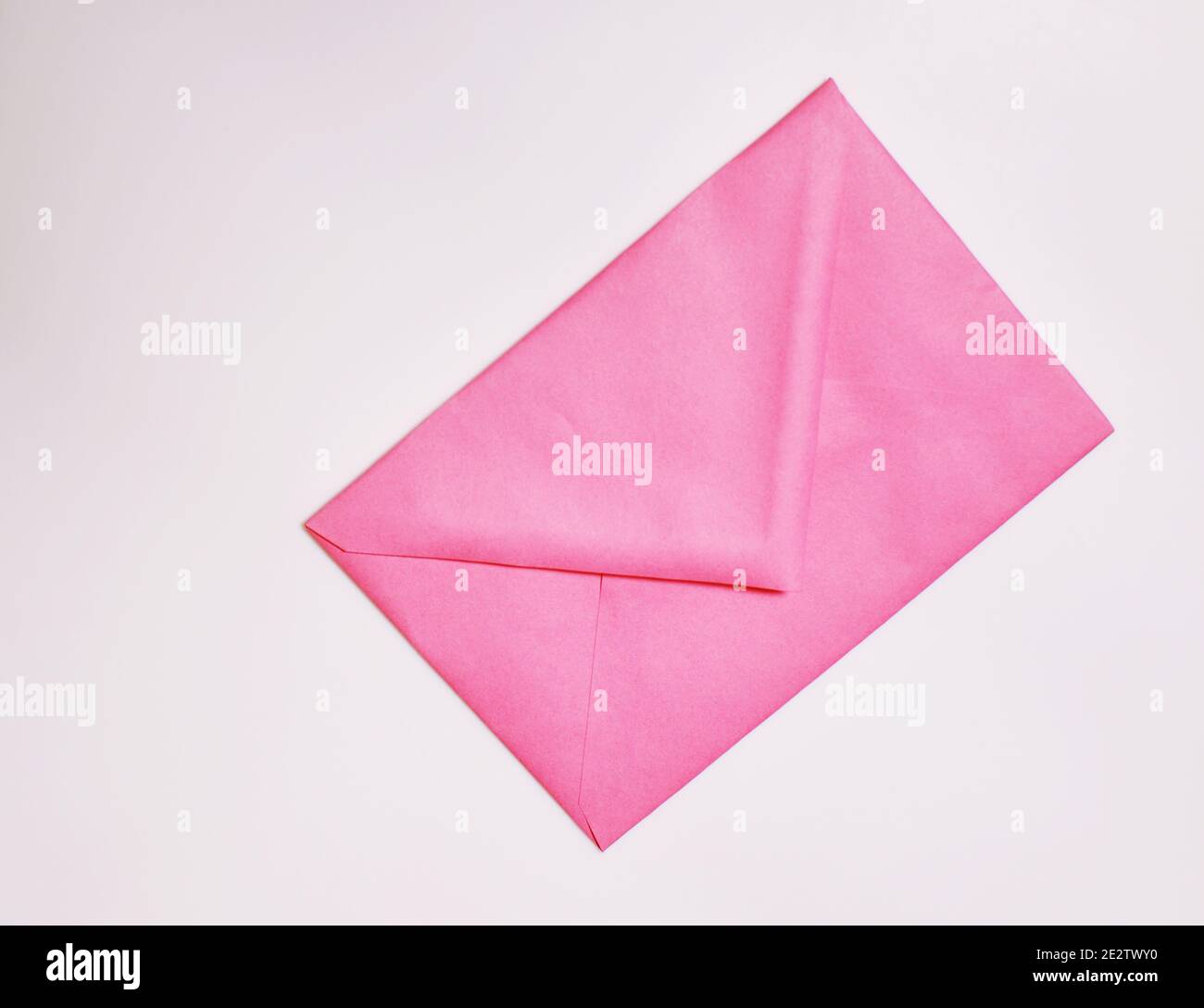 Closed pink envelope on white background with copy text Stock Photo