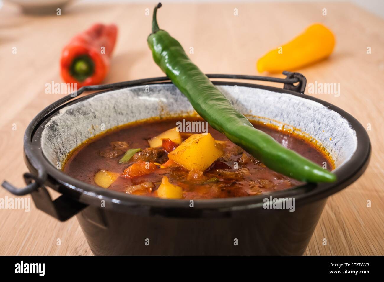 Hungarian Beef Goulash or Gulyas Soup or Stew Served in a Small Cauldron with Potatoes, Meat, Paprika and Chili and Bell Pepper Stock Photo
