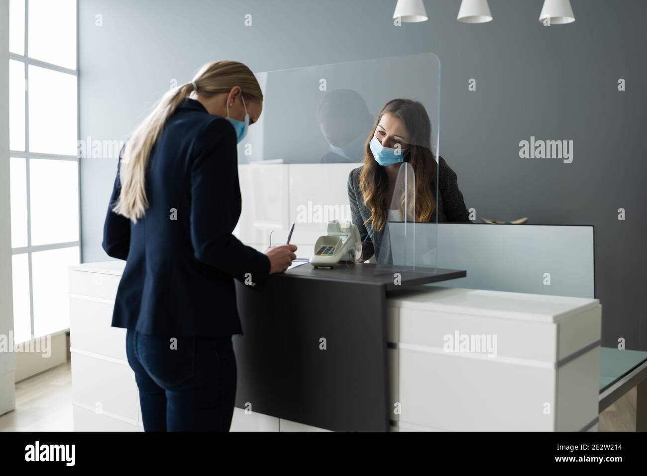 Hotel Reception Desk Protected By Medical Mask From Covid 19 Stock
