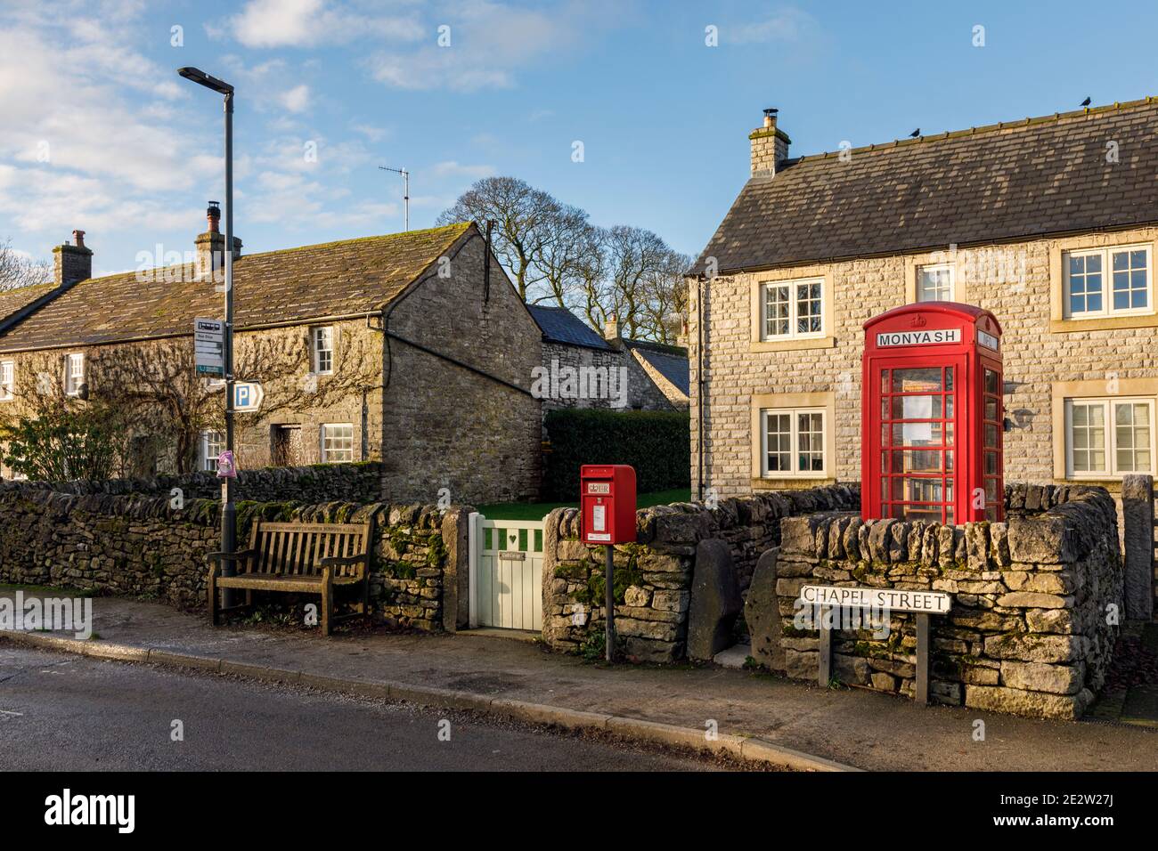 Postbox and telephone kiosk (now repurposed as a book exchange and information point), Monyash, Peak District National Park, Derbyshire Stock Photo