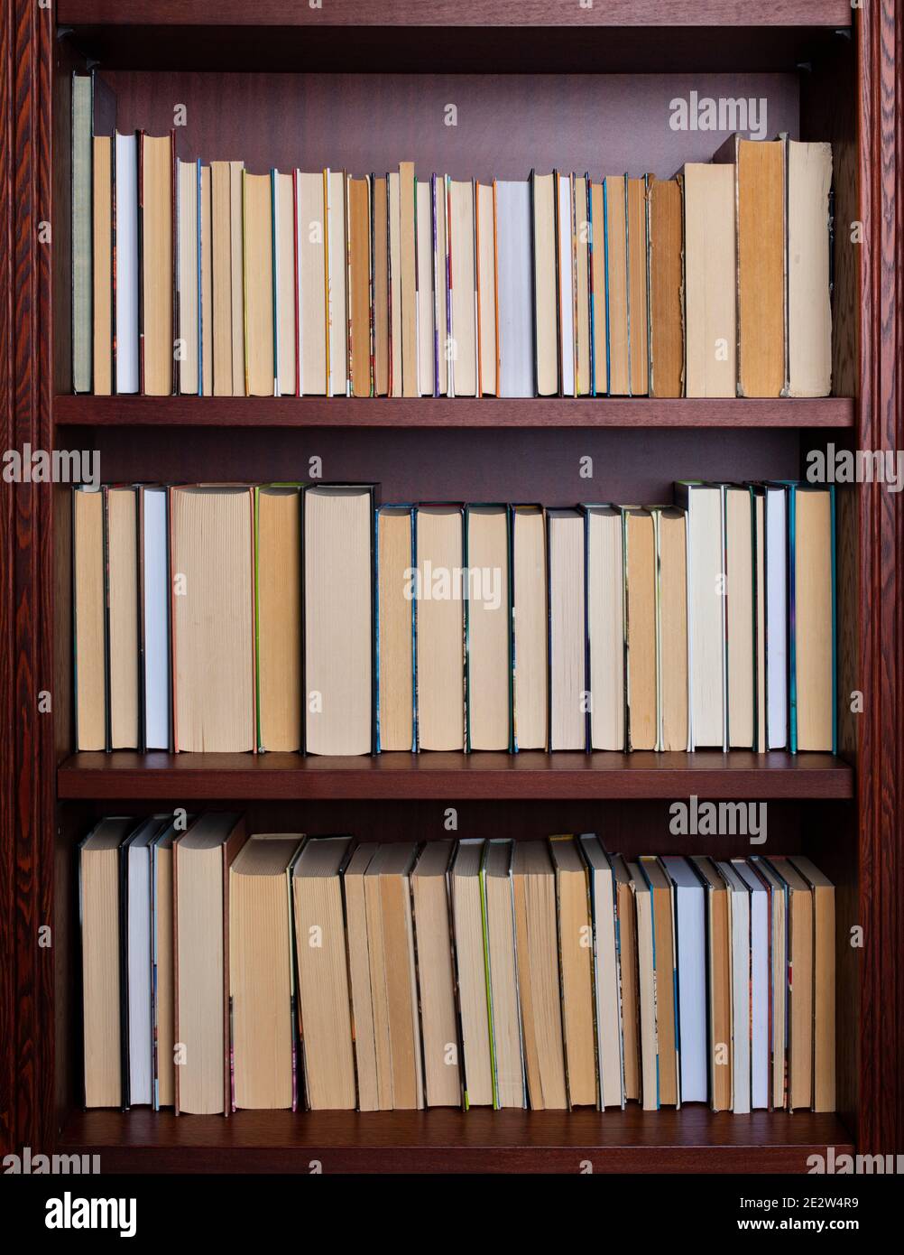 Bookshelf with books displayed backwards Stock Photo Alamy