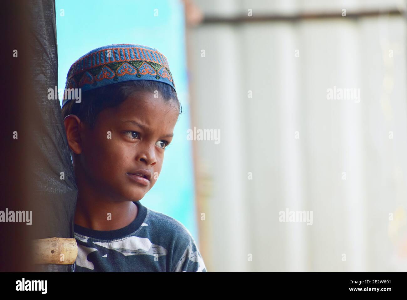 Hyderabad, India - March 05, 2020:  A young Rohingya 7 year old child stands alone at the side of the Rohingya refugee camp at Balappur, Hafiz Baba Na Stock Photo