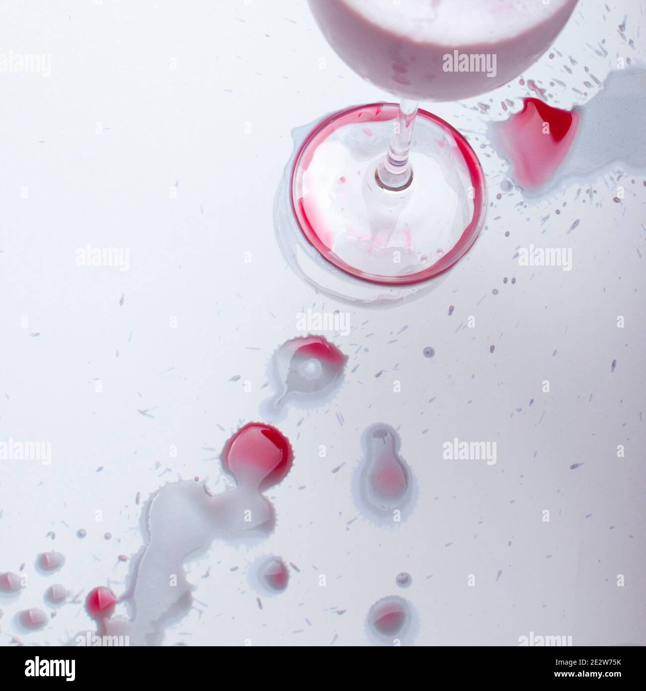 Red wine spots on a white background and a glass, after a party Stock