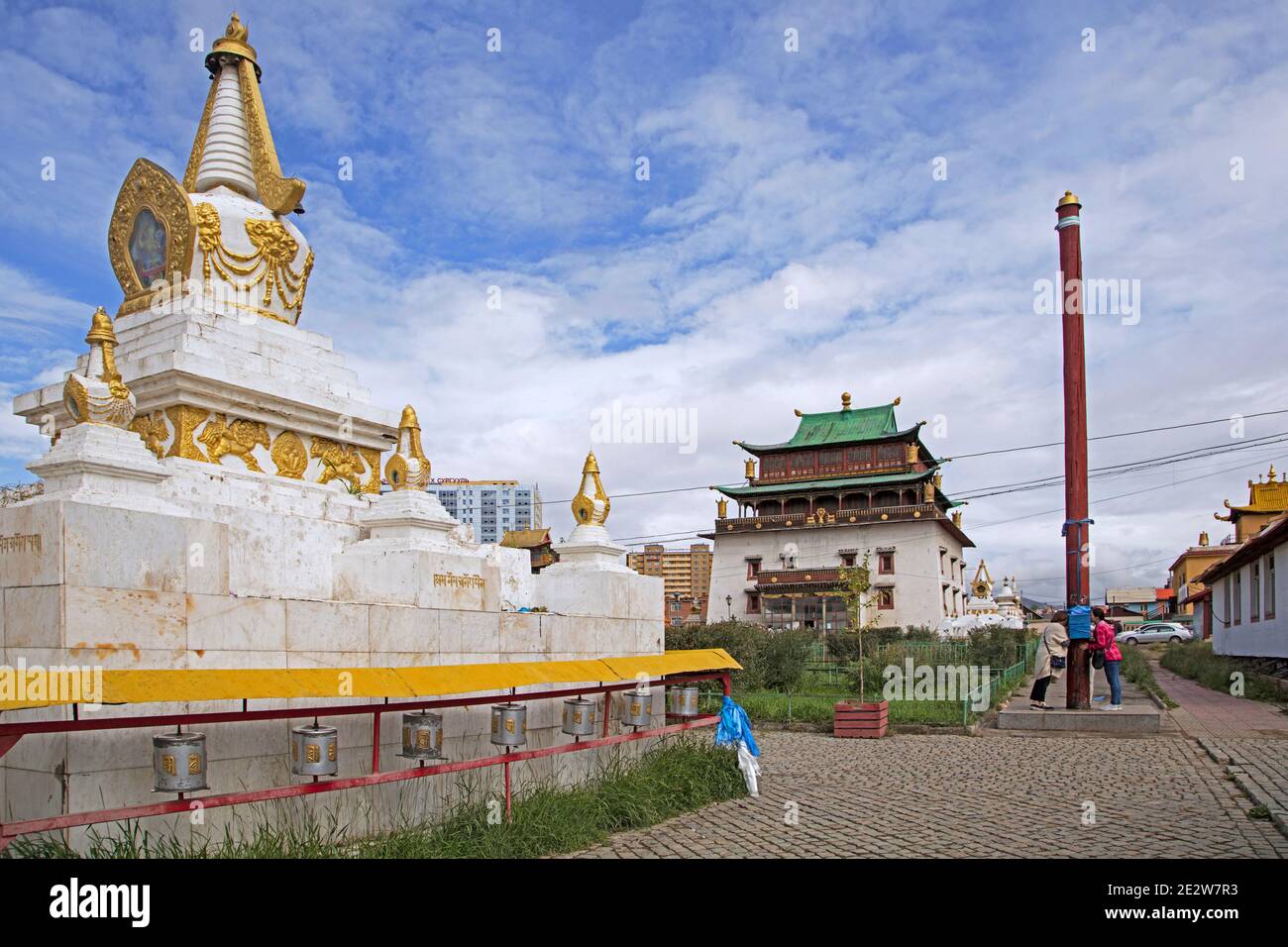 Stupa and Mongolians praying at pole / prayer post in the Gandan / Gandantegchinlen Monastery in the capital city Ulaanbaatar / Ulan Bator, Mongolia Stock Photo
