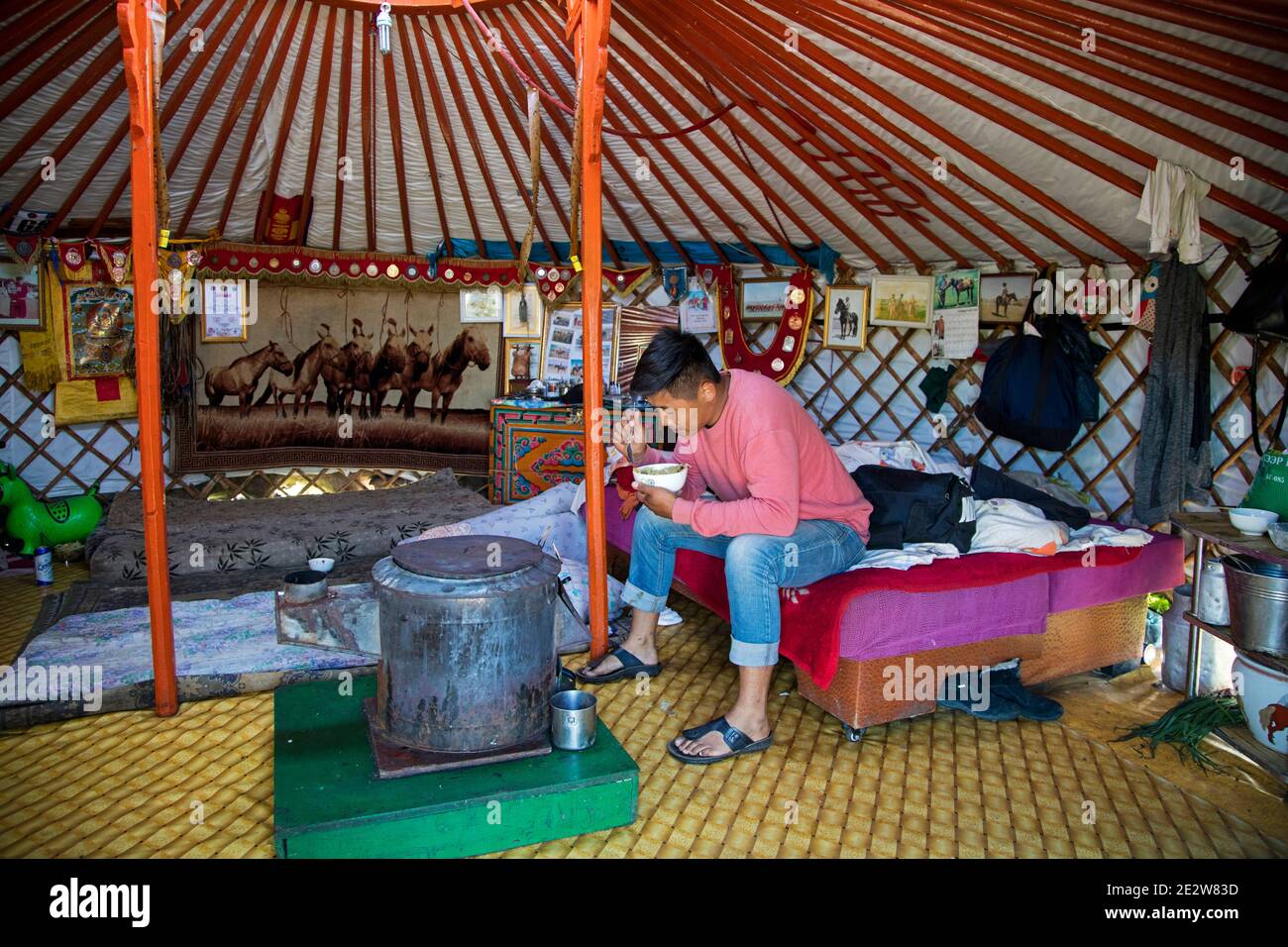Mongol man eating inside traditional Mongolian ger / yurt, portable round tent on the steppe of Mongolia Stock Photo