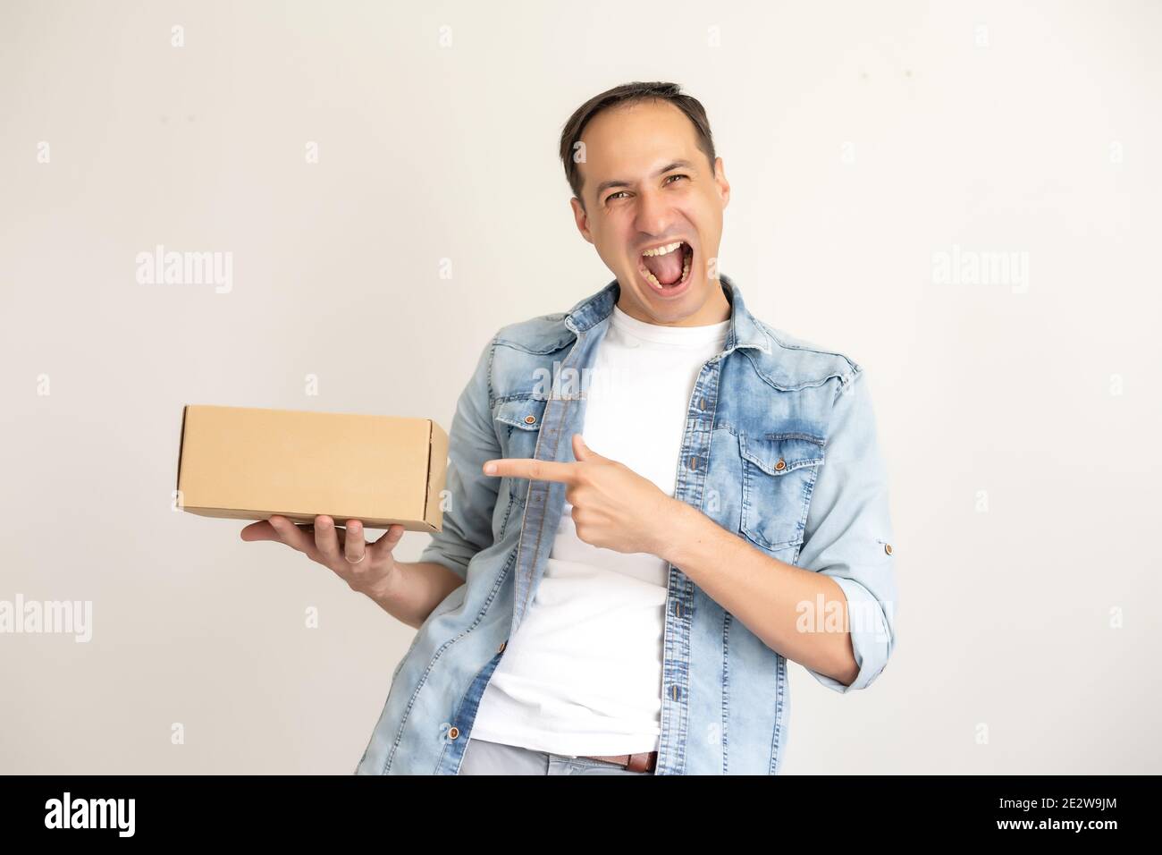 smiling delivery man holding a big parcel isolated on white Stock Photo ...