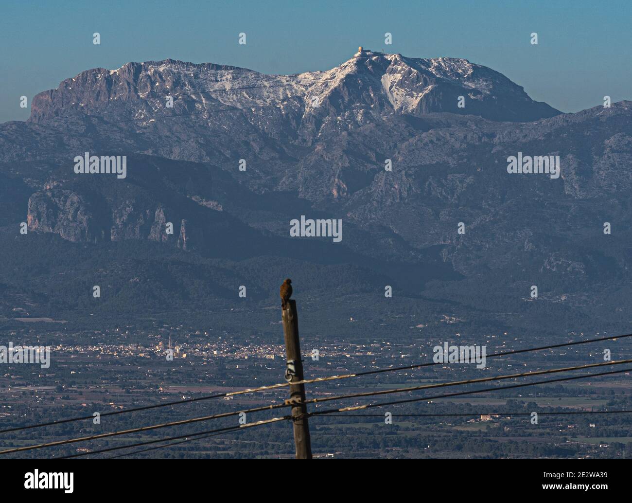 panoramic view from the sanctuary or Randa, in Mallorca, with the snow-capped mountains in the background.A bird of prey is observed resting on the el Stock Photo