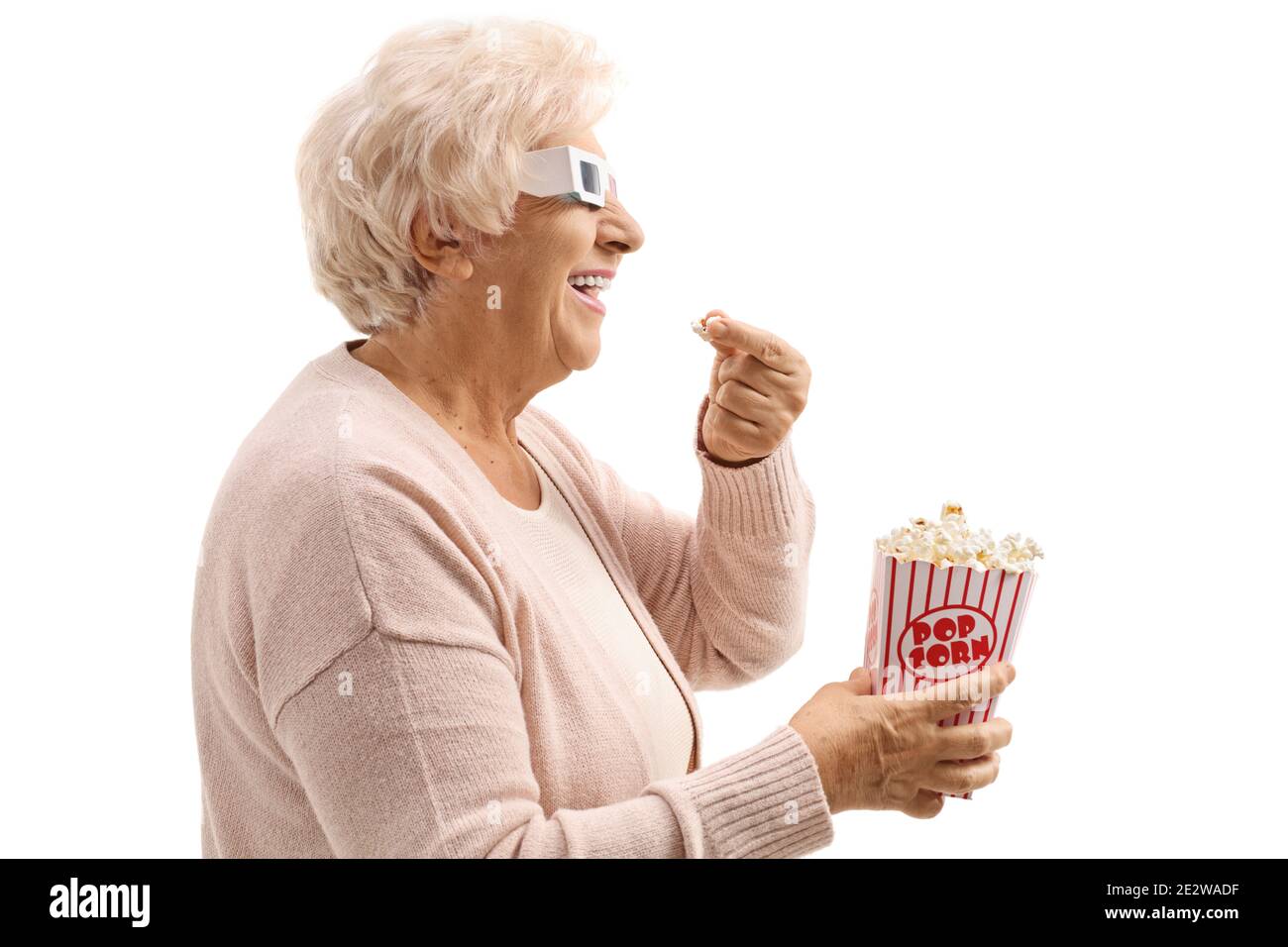 Profile close up shot of a mature woman with 3d cinema glasses and a box of popcorn isolated on white background Stock Photo