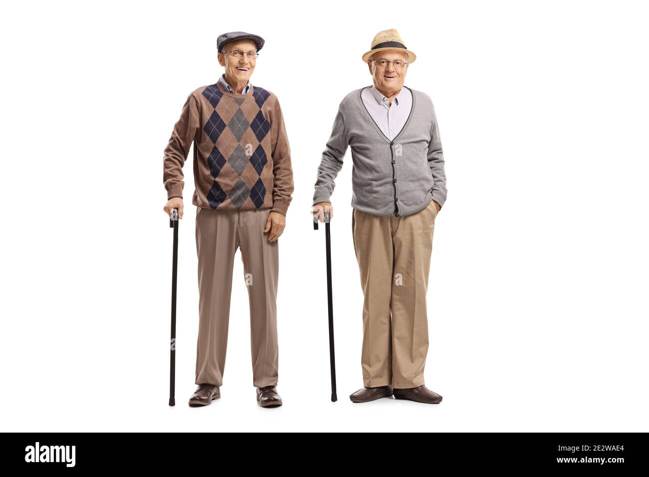 Full length portrait of elderly male friends standing with canes isolated on white background Stock Photo