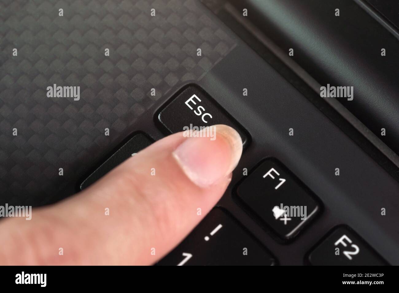 Detail on woman finger pressing the esc key on laptop keyboard Stock Photo
