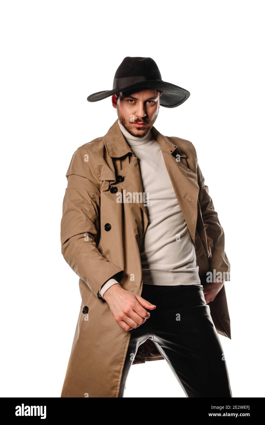 Portrait of a handsome young guy wearing leather black pants, and beige coat isolated on white background Stock Photo