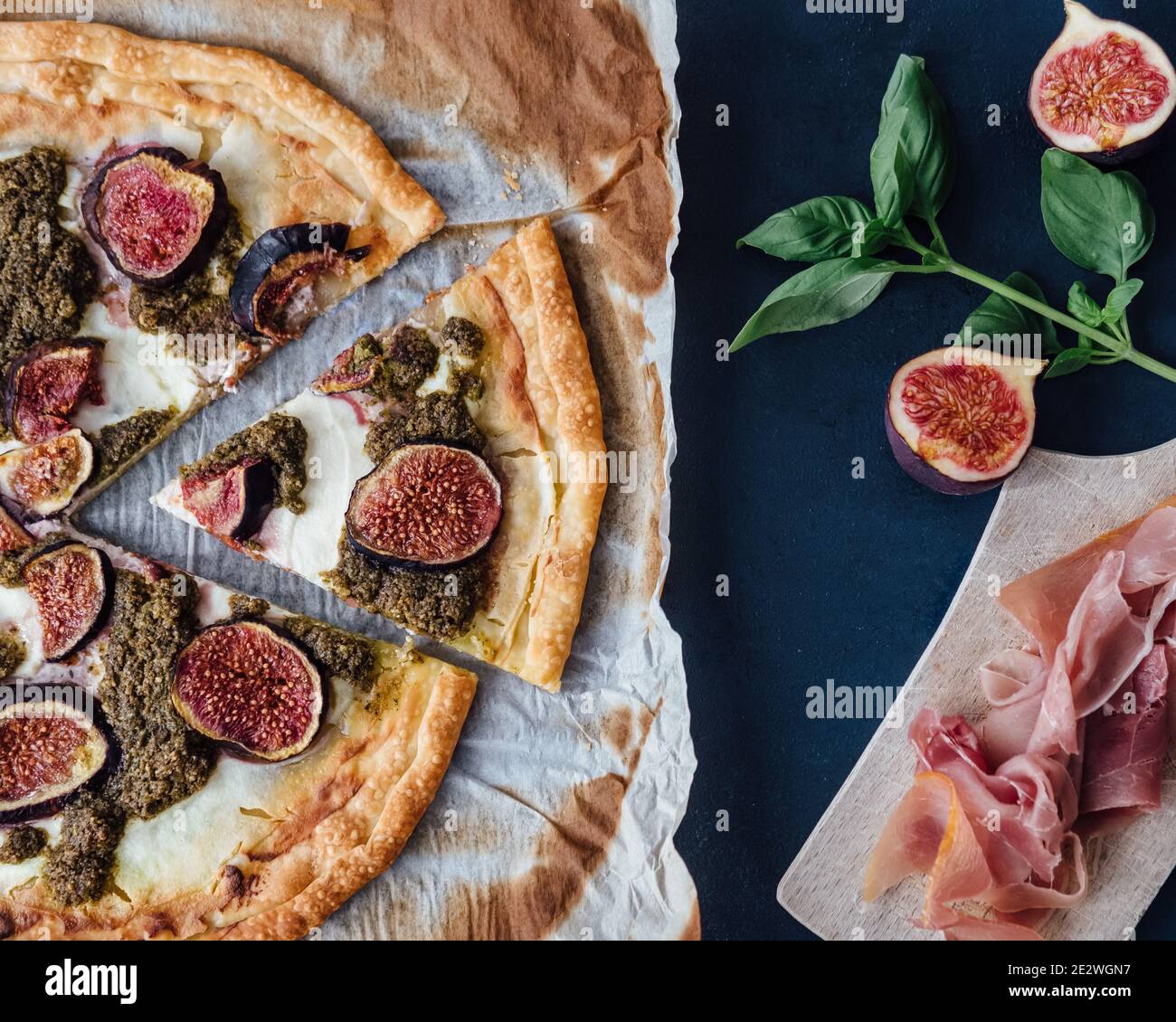 Top down view of ricotta, fig and pesto pizza with prosciutto Stock